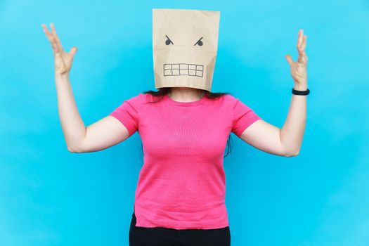 Woman standing with a cardboard on her head with angry face. Emotions.