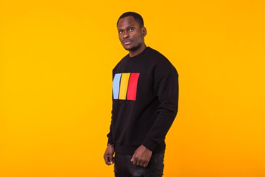 Studio shot of young handsome African man wearing hoodie against white background.