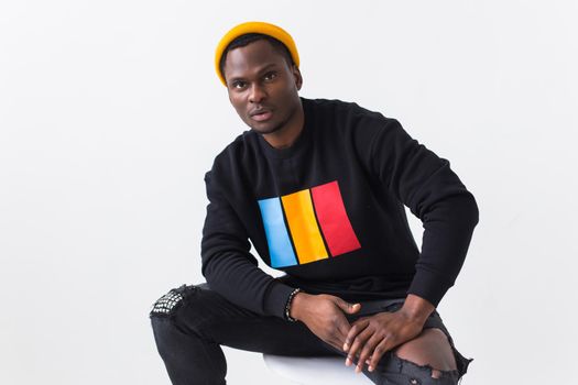 Studio shot of young handsome African man wearing hoodie against white background.