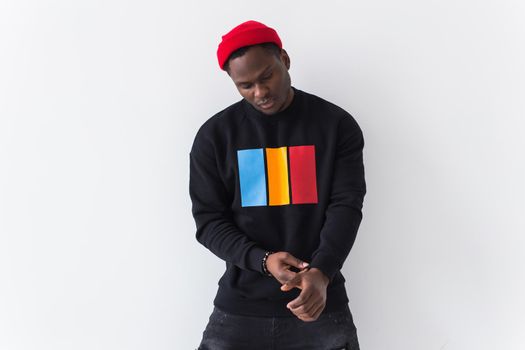 Studio shot of young handsome African man wearing hoodie against white background.