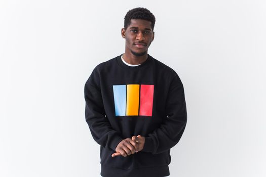 Studio shot of young handsome African man wearing hoodie against white background.