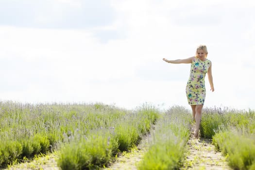 Woman standing with open arms on a lavender field