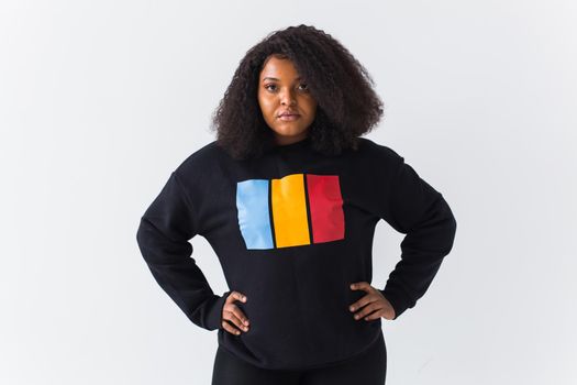 Beautiful African American woman posing in black hoodie on a white background. Fashion with afro hairstyle.