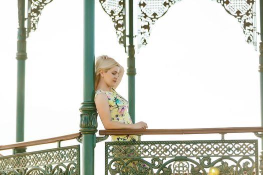 Pretty, atractive woman standing in a gazebo in a park