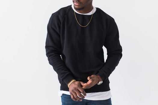 Portrait handsome young black man dressed in jeans and hoodie on white background. Street fashion and modern youth culture