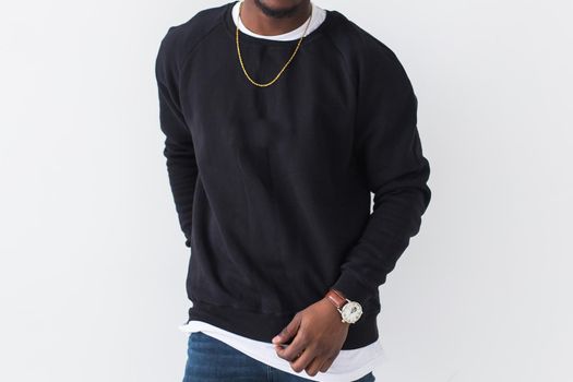 Handsome African American man posing in black hoodie on a white background. Youth street fashion photo with afro hairstyle