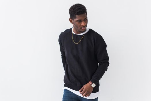 Studio shot of young handsome African man wearing hoodie against white background.