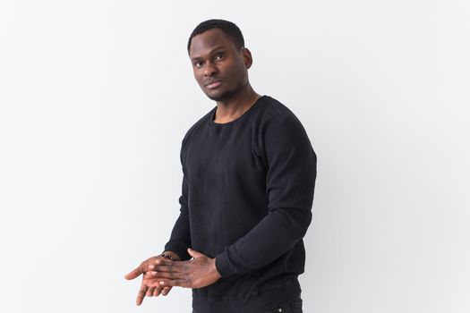 Portrait handsome young black man dressed in jeans and hoodie on white background. Street fashion and modern youth culture