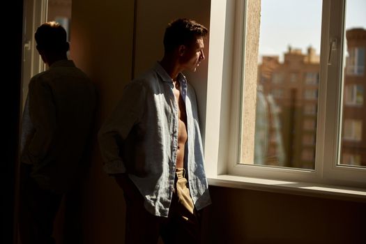 Happy beautiful handsome smiling caucasian man is relaxing at modern light home on the morning sun