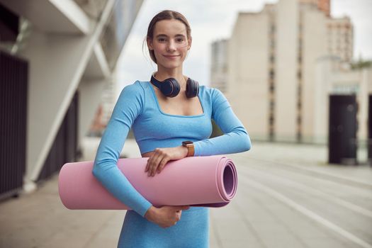 Beautiful fit caucasian woman is doing exercises outdoors at the city