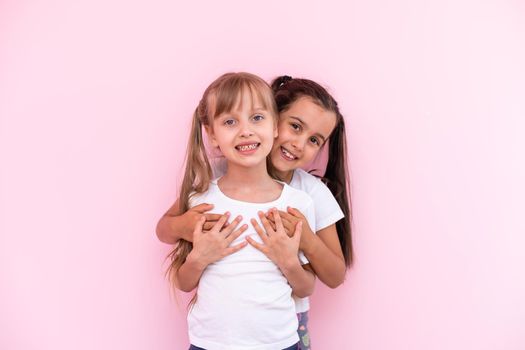 Happy funny girl twins sisters hugging and laughing