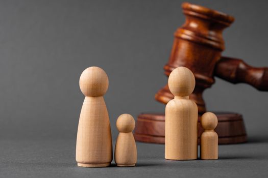 Wooden toy family and judge mallet close up. Family divorce concept