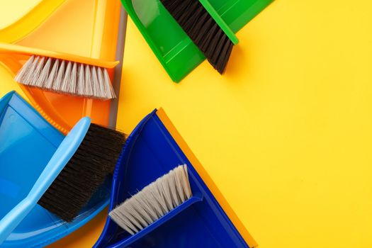 Set of cleaning supplies on yellow color background, top view