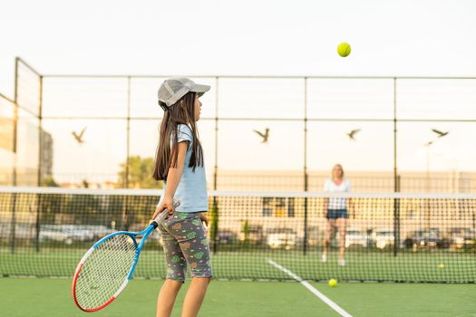 Portrait of a cute little girl playing tennis