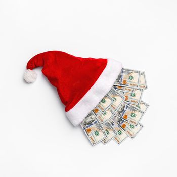 New year or Christmas gift concept. Money inside Santa hat. Christmas hat full of 100 dollar bill isolated on white