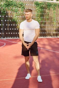 man in white t-shirt on the sports ground workout motivation. High quality photo