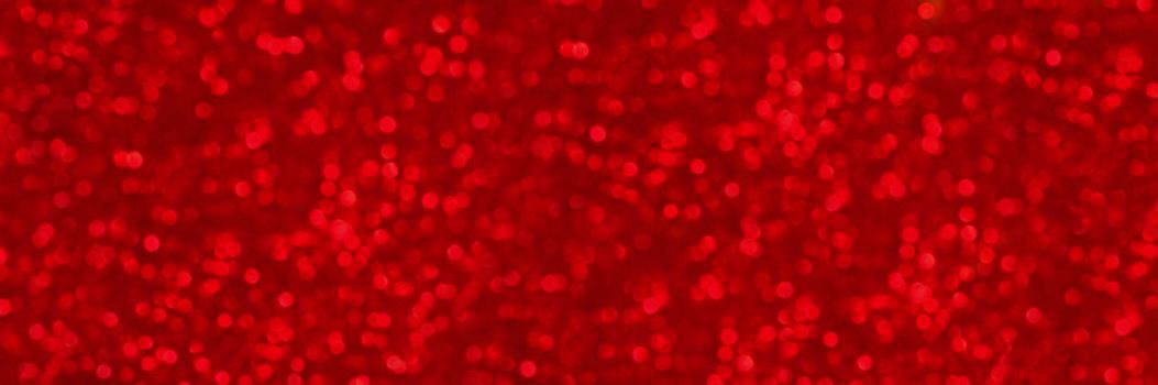 Abstract shiny glitter christmas or new year background. Ruby glitter background with sparkling texture. Red shimmering light, sequins sparks and glittering glow foil background. Long banner or poster