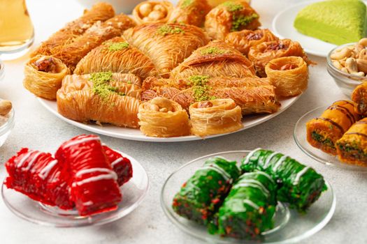 Various Turkish sweets and cup of tea on white textured background, close up