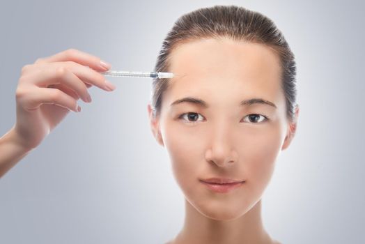 Portrait of a beautiful woman, injection of a cosmetic product in facial skin