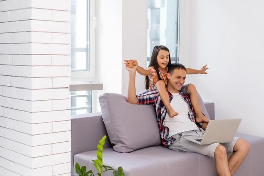 Father and daughter laughing on laptop