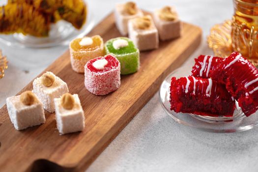 Various Turkish sweets and cup of tea on white textured background, close up
