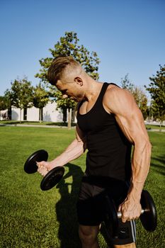 sporty man in black t-shirt in the park training lifestyle. High quality photo