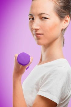 Woman exercises with a dumbbell, side view