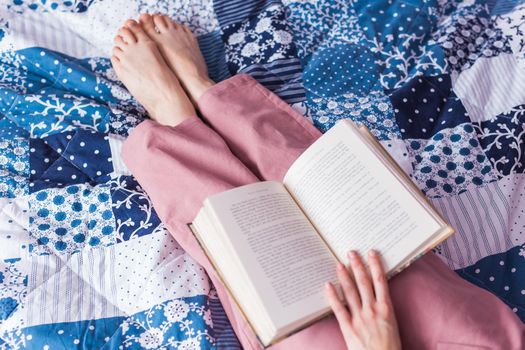 Happy woman wears pajama and relaxing at home and reading a book. Stay home. Quarantine pandemic coronavirus.