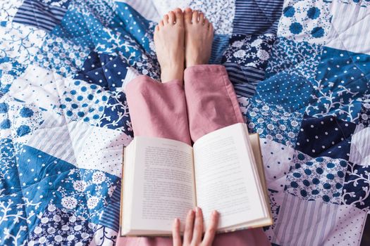 Happy woman wears pajama and relaxing at home and reading a book. Stay home. Quarantine pandemic coronavirus.