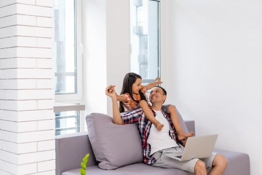 Father and daughter laughing on laptop