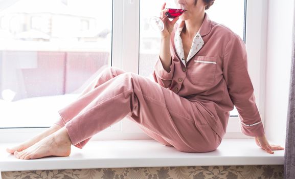 Young brunette woman relaxing at home reading book. Quarantine, isolation, coronavirus pandemic world. Stay home.