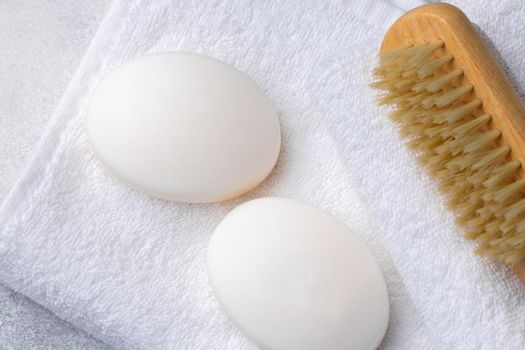 Bar of natural handmade soap, towel and spa objects, close up