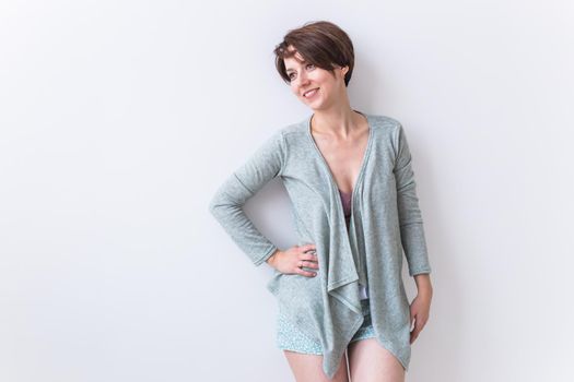 Beautiful young woman smiling against white background. Comfortable homewear, home relaxation and female fashion.
