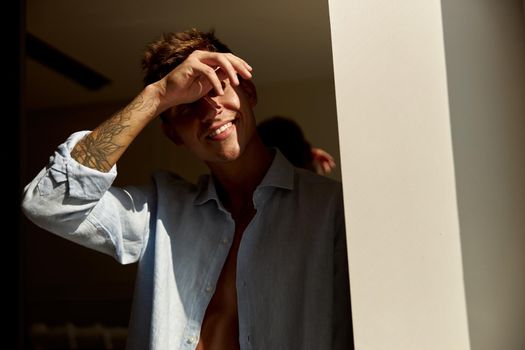 Happy beautiful handsome smiling caucasian man is relaxing at modern light home on the morning sun