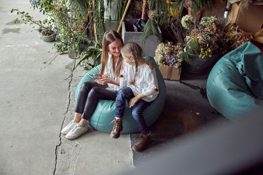 Happy caucasian mother with young beautiful cheerful daughter are having time together