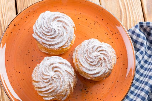 Small french cookies profitroles with sugar powder close up