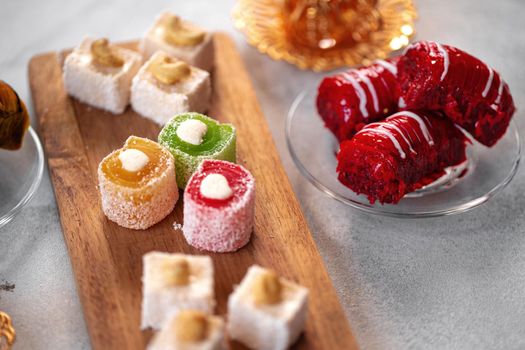 Various Turkish sweets and cup of tea on white textured background, close up