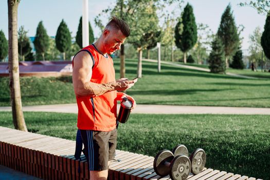 athletic man in red t-shirt in fitness park. High quality photo