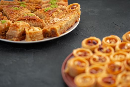 Delicious baklava dessert in oriental setting on black background, close up