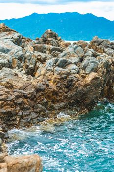 Beauty panorama pure blue lazure empty sea skyline, vivid brown gray rock shabby cliff, water splash, cumulus cloud sky, mountain island background. Concept sea tourism after pandemic, power in nature.