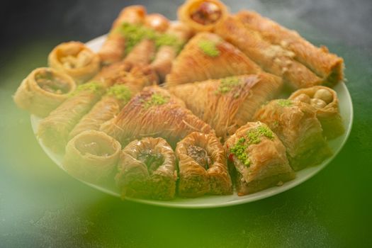 Delicious baklava dessert in oriental setting on black background, close up