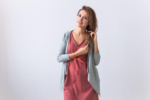 Beautiful young woman smiling against white background. Comfortable homewear, home relaxation and female fashion.