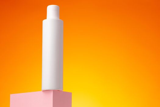 Blank white cosmetic container against orange background, copy space