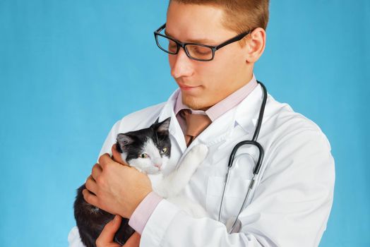 Man doctor veterinarian in a glasses holds a cat