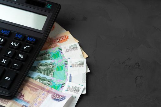 Close up photo of stack of Russian money rubles with calculator. High quality photo
