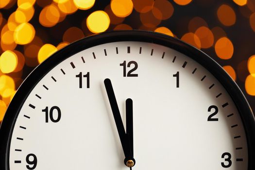 ew Year eve concept with alarm clock against blurred garland background