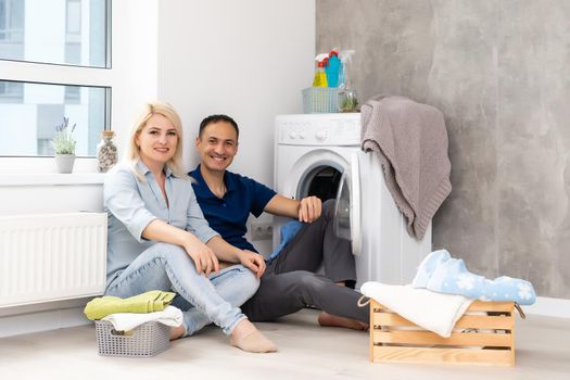 man and woman with washing machine in apartment