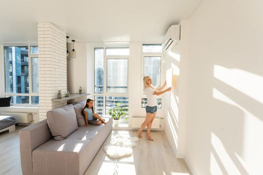 mother and daughter hangs a large photo canvas at home