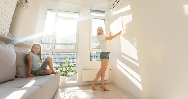 mother and daughter hold photo canvas at home