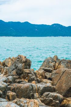 Vertical view shabby cliff cumulus cloud sky mountain island background pure blue lazure empty sea skyline. Gray brown stone rock texture vivid colour. Concept tourism after pandemic, power in nature.